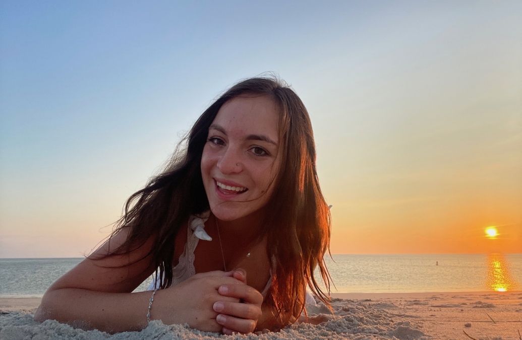 close up of a young woman lying on a beach at sunset