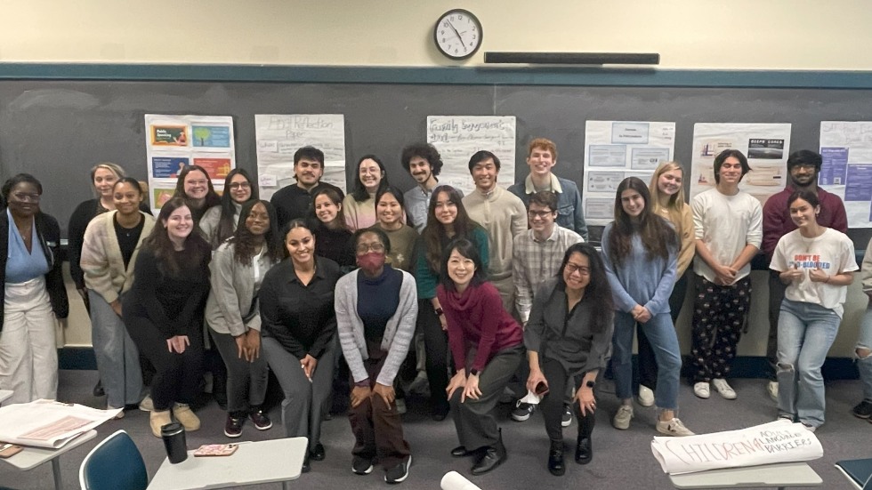 large group of people smiling and posing in a classroom