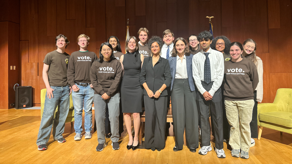 Brown Votes student organizers and Civic Engagement Fellows stand together on stage, smiling for a group photo after the Providence Mayoral Candidate Forum at the Salomon Center for Teaching.