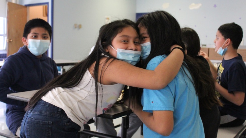 Masked D'Abate students sitting at a table